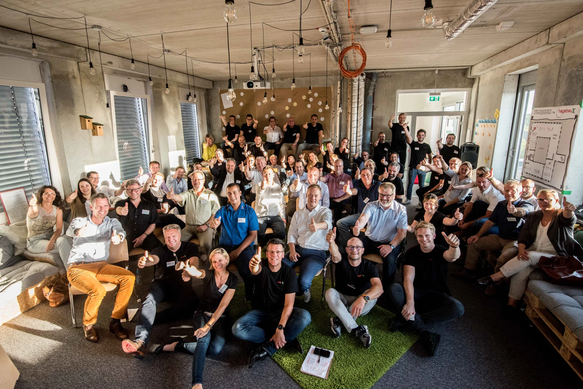 Gruppenbild einer Zukunftswerkstatt, rund fünfzig Teilnehmende mit erhobenen Daumen