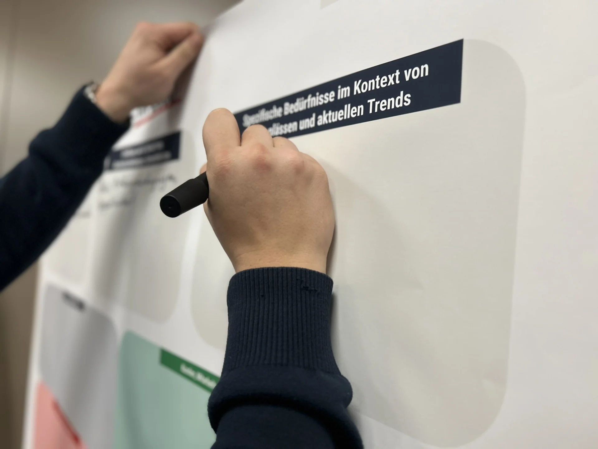 Hand beschriftet ein Whiteboard zu beruflichen Bedürfnissen und aktuellen Trends