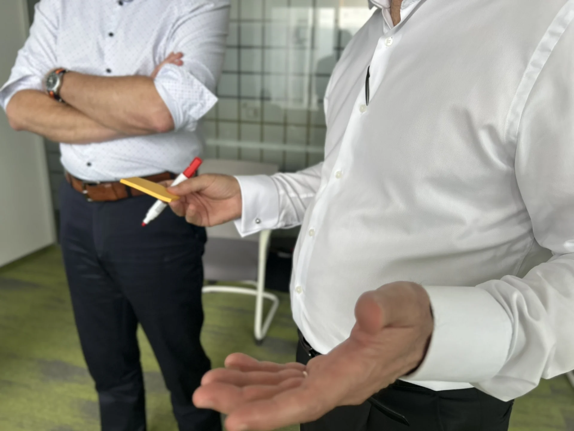 Zwei Führungskräfte im Gespräch, einer mit Stiften in der Hand