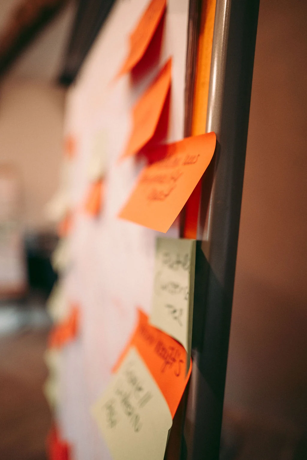 Pinnwand mit orangen und gelben Haftnotizen aus dem Workshop