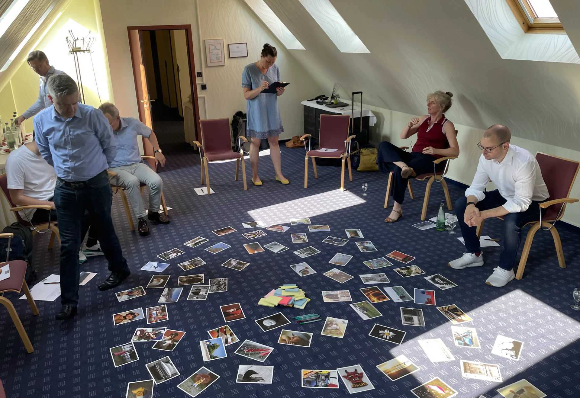 Führungsteam im Stuhlkreis, Bildkarten liegen ausgebreitet auf dem Boden